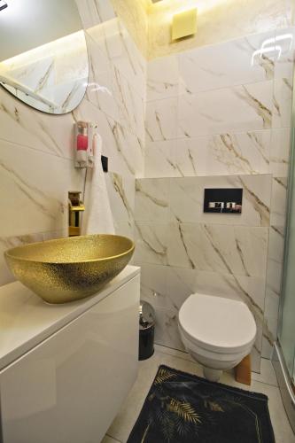 a bathroom with a gold sink and a toilet at Motel Na Zbójeckiej in Skawa