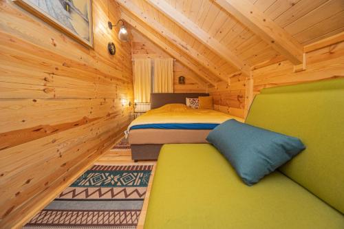 een slaapkamer met een bed in een houten hut bij Rustic house in Kolašin