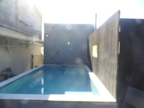 a large swimming pool in a room with a wall at Lake Lodge Motel Rotorua in Rotorua