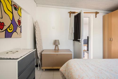 a bedroom with a bed and a painting on the wall at Central, Cozy, Comfy, 1BR House, Free Parking & Fast Wi-Fi, 4ppl in Bodrum City