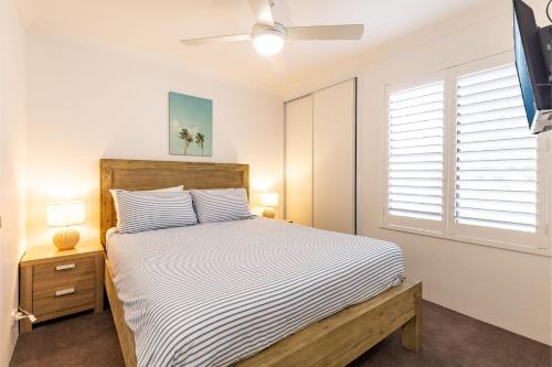 a bedroom with a bed and a window at Bay Parklands, 36 2 Gowrie Avenue - close to the water with Air con, WiFi, pool & spa & tennis court in Shoal Bay