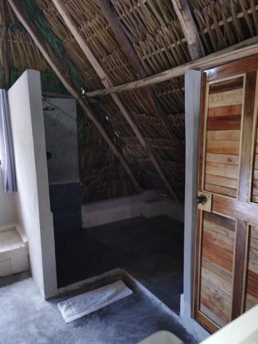 a bathroom with a shower in a straw roof at Casa Mate BeachFront Cabañas El Cuyo in El Cuyo