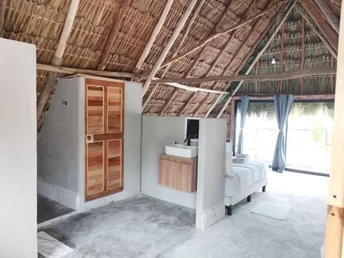 a bedroom with a bed and a large window at Casa Mate BeachFront Cabañas El Cuyo in El Cuyo