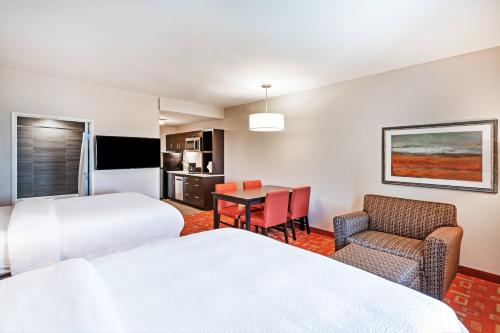 um quarto de hotel com duas camas e uma mesa e cadeiras em TownePlace Suites Dallas Plano/Richardson em Plano