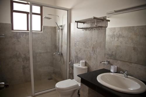 a bathroom with a shower and a toilet and a sink at Bay Vista in Arugam Bay