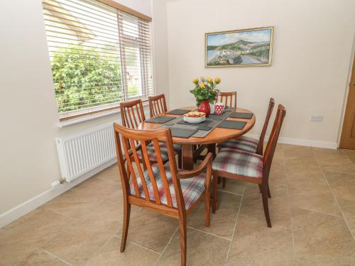 a dining room with a table and chairs at Cae Glas in Pwllheli