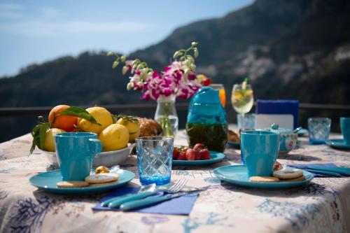 una mesa con platos de comida y fruta. en Amalfi Sea View en Scala