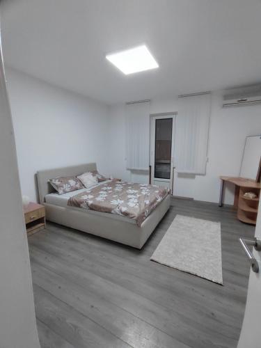 a bedroom with a bed in a white room at Queen 3 in Niš