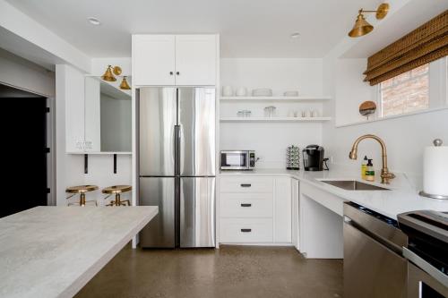 a kitchen with white cabinets and a stainless steel refrigerator at The World's Fair Home in Portland