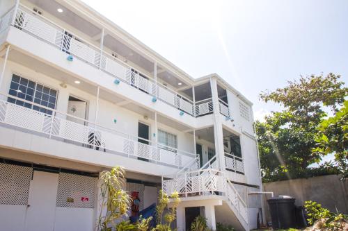 a white building with white balconies and trees at Apartamentos Chalet del Mar in San Andrés