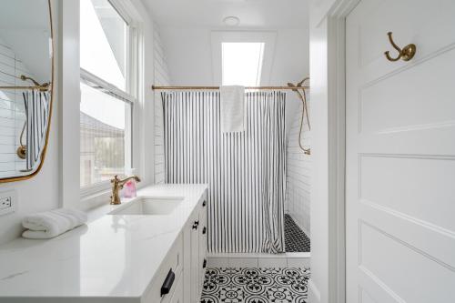 a white bathroom with a shower and a sink at The World's Fair Home in Portland