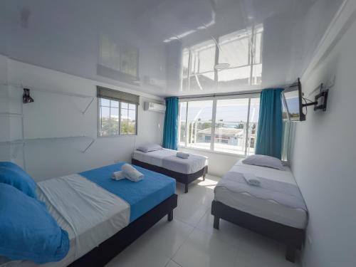 a bedroom with two beds and a window at Apartamentos Chalet del Mar in San Andrés