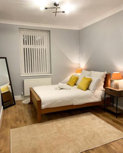 a bedroom with a bed with two yellow pillows at Cardiff Home in Cardiff