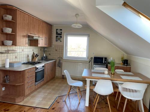 a kitchen with a table and some white chairs at Noclegi Nad Małym Jeziorakiem in Iława