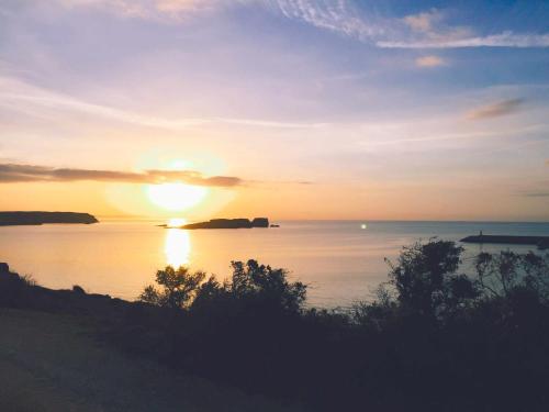 a sunset over a body of water with the sun setting at Casa Biota in Sagres