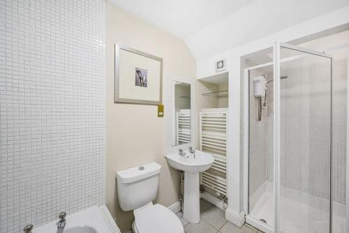 a white bathroom with a toilet and a sink at Grove House - By Sigma Stays in Newcastle under Lyme
