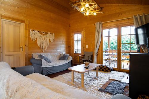 ein Wohnzimmer mit einem Sofa und einem Tisch in der Unterkunft Riverside Forest Retreat-Chalet in Karpenisi