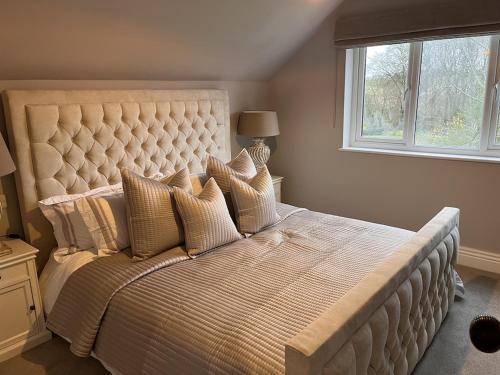 a large bed in a bedroom with a window at Little Corners in Shawford