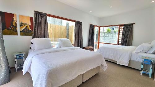 um quarto com 2 camas e uma janela em The Beach House Raumati em Paraparaumu