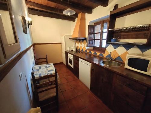 a kitchen with a sink and a microwave at Don Camino Low Cost in Villalcázar de Sirga