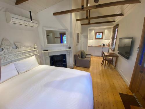 ein Schlafzimmer mit einem weißen Bett und einem Kamin in der Unterkunft Bon Accord in Sale