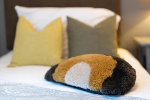 a stuffed animal laying on a bed with pillows at High Street Town House in Manchester
