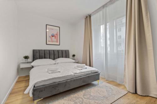 une chambre avec un lit et une grande fenêtre dans l'établissement 2 BR Apt Steps to Nivy Station, à Bratislava
