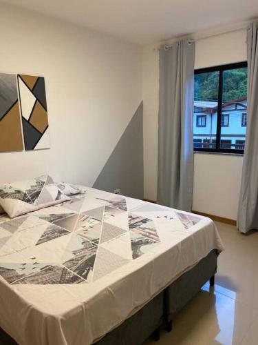 1 dormitorio con 1 cama en una habitación con ventana en Apartamento com vista para as montanhas e natureza, en Petrópolis