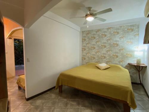 um quarto com uma cama e uma ventoinha de tecto em Casa Maiana em Sámara