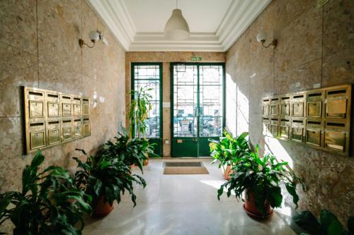 a hallway with potted plants and a green door at Alameda Apartments & Rooms in Lisbon