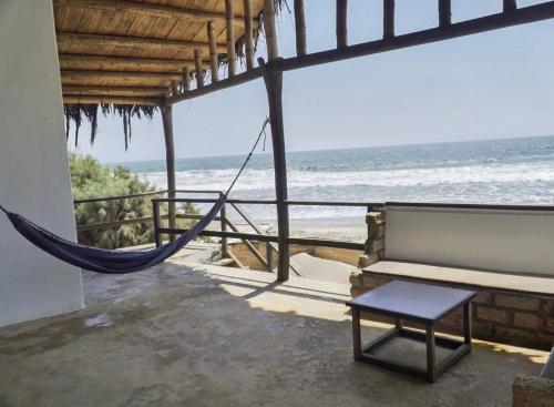 a porch with a hammock and a view of the ocean at Mancora Soul in Máncora