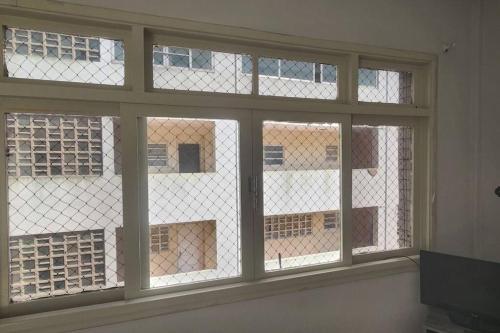 okno z czterema oknami w pokoju w obiekcie Studio Frente à Praia Boqueirão w mieście Santos