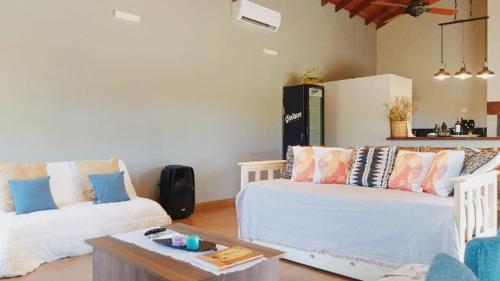 a living room with two white couches and a table at Casa con pileta en Paso de la Patria in Paso de la Patria