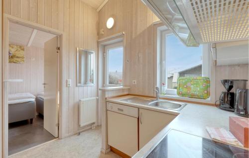 eine Küche mit einem Waschbecken und einem großen Fenster in der Unterkunft Strandpark 6 in Schönhagen