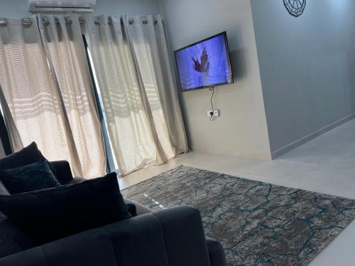a living room with a couch and a flat screen tv at Aqua view Beach Apartment in Bathurst