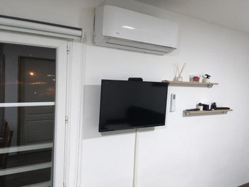 a flat screen tv on a wall next to a window at Mia apartmani - novoizgradjeni objekat in Gornji Milanovac