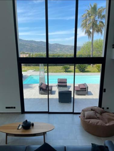 - un salon avec vue sur la piscine dans l'établissement Villa EDEN, à La Roquette-sur-Siagne