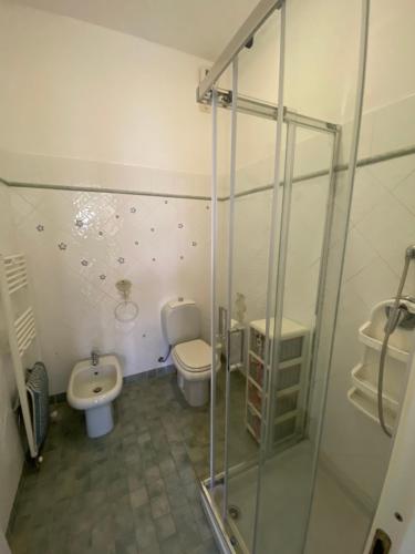 une salle de bain avec toilettes et douche en verre dans l'établissement BEACH HOUSE STEFI, à Golfo Aranci