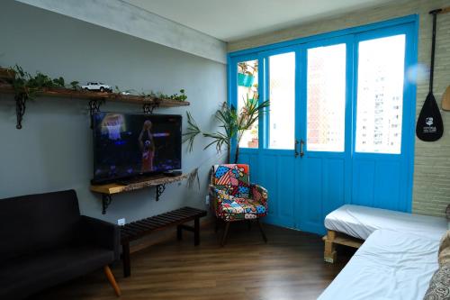 a living room with a blue door and a tv at Maravilhoso AP 3 Quartos Familiar - Wi fi- Praia do Canto in Vitória