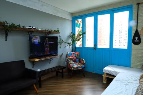 d'un salon avec une porte bleue et une télévision. dans l'établissement Maravilhoso AP 3 Quartos Familiar - Wi fi- Praia do Canto, à Vitória