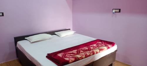 ein weißes Bett mit einer roten Decke drauf in der Unterkunft Govind Niwas Homestay in Jagdalpur