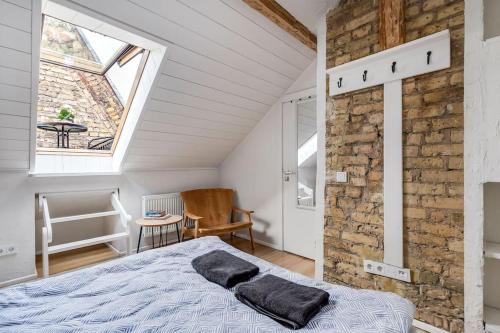 ein Schlafzimmer mit einem Bett und einer Ziegelwand in der Unterkunft Luxury apartment in Gediminas avenue with terrace in Vilnius