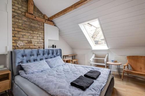 a bedroom with a blue bed in a attic at Luxury apartment in Gediminas avenue with terrace in Vilnius