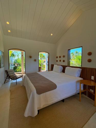 a large bedroom with a large bed and two windows at Villa Canziani & Donato in Pôrto de Pedras