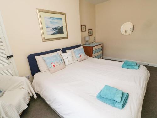 um quarto com 2 camas com toalhas azuis em Victoria Cottage em Amble