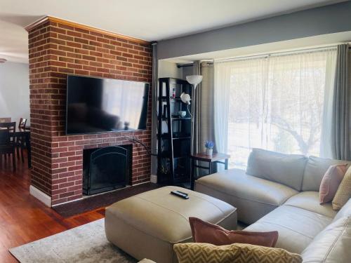 a living room with a couch and a brick fireplace at Spacious single family home close to VA and DC 5mins to MGM in Fort Washington
