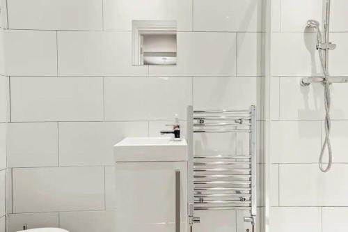 baño blanco con ducha y lavamanos en Elegant Flat - Sleeps 8, en Bristol