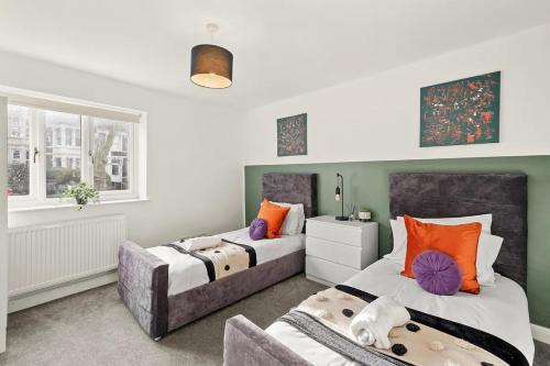 a bedroom with two beds and a couch at Elegant Flat - Sleeps 8 in Bristol