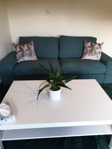 uma sala de estar com um sofá e uma mesa de café branca em Shelly's Place em Glasgow