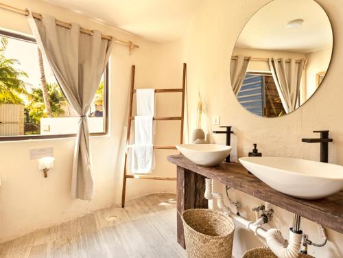 a bathroom with two sinks and a mirror at Alquimia Hotel Boutique in Tulum